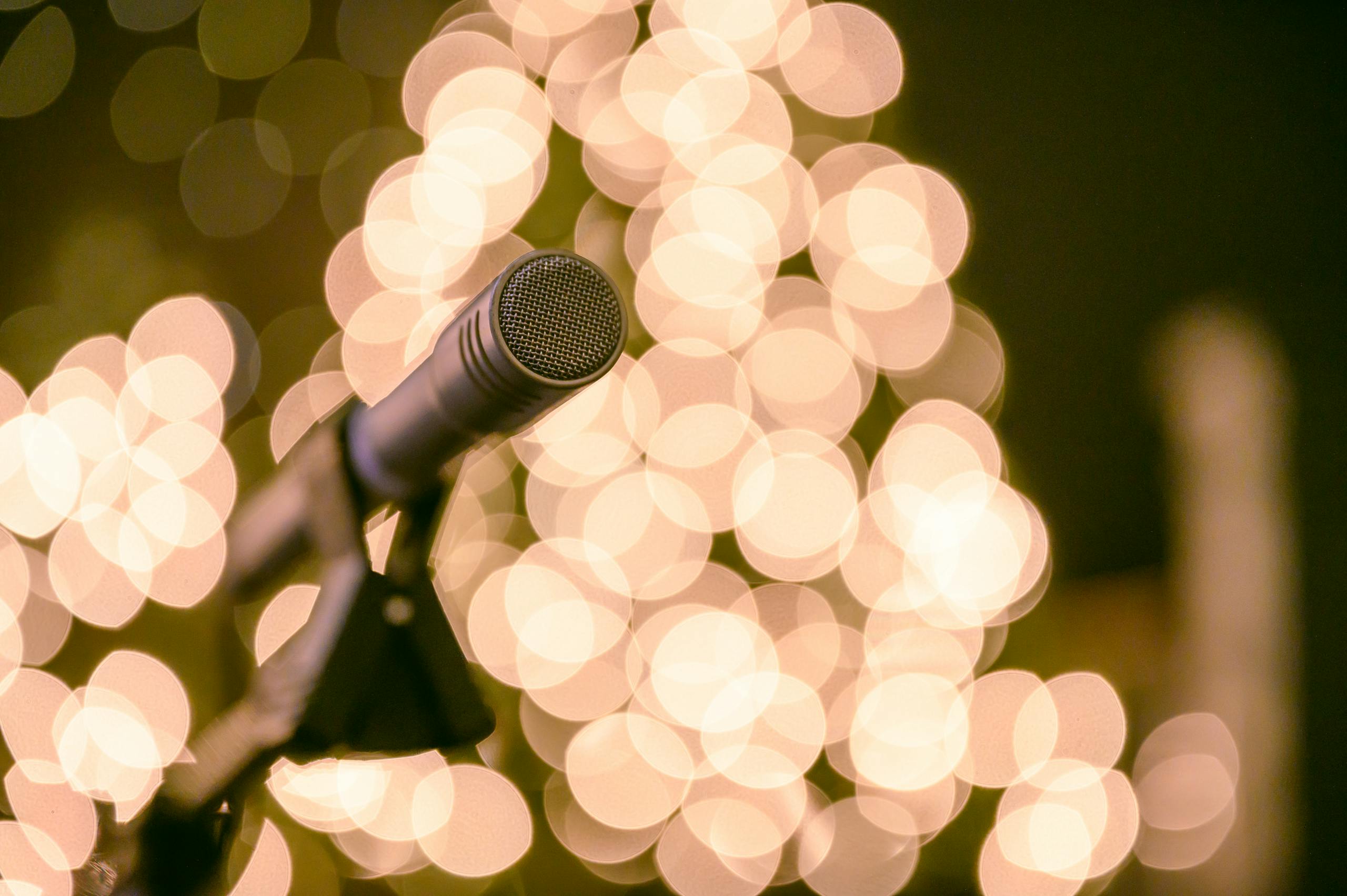 Photo par Brett Sayles Close-up of a classic microphone with a warm, bokeh light backdrop, creating a retro and artistic vibe.
