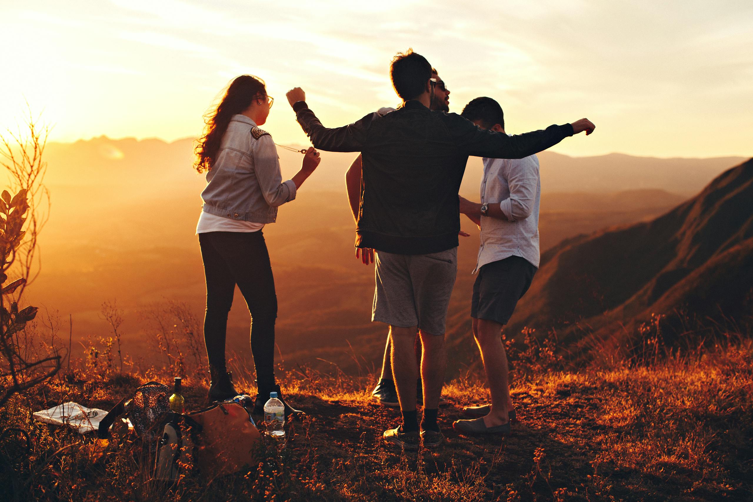 Photo par Helena Lopes Joyful group of young adults enjoying a sunset view in a mountainous landscape in Brazil.